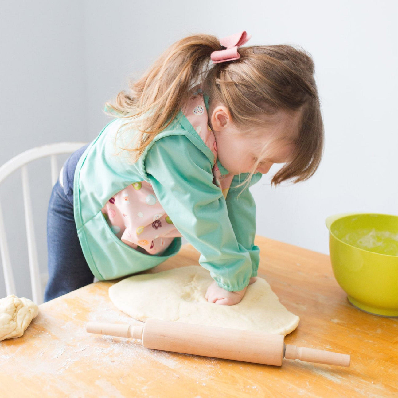 Uśmiechnięte dzieci mieszają składniki w misce tworząc zdrową sałatkę owocową