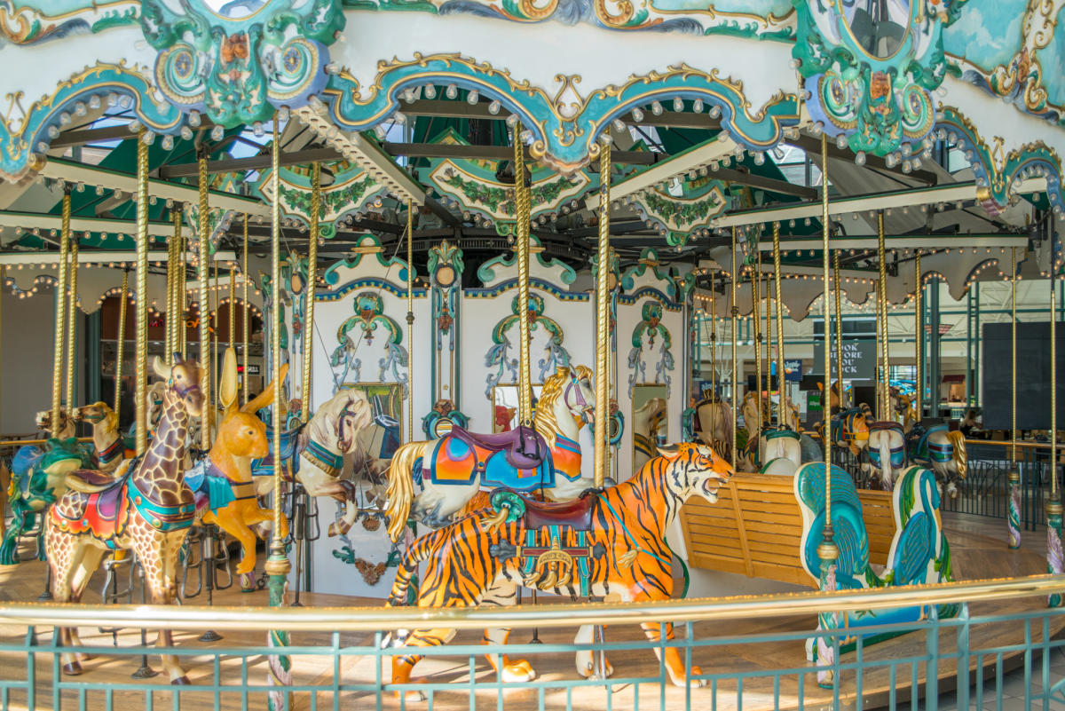 Szczęśliwe dzieci na kolorowych karuzelach w dużym europejskim parku rozrywki