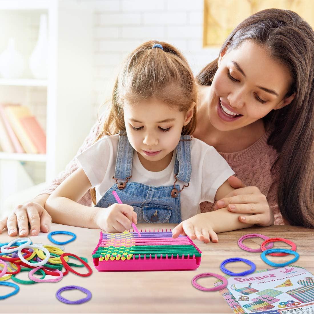 Grupa dzieci uśmiechniętych przy małych krosnach tkackich z kolorowymi nićmi