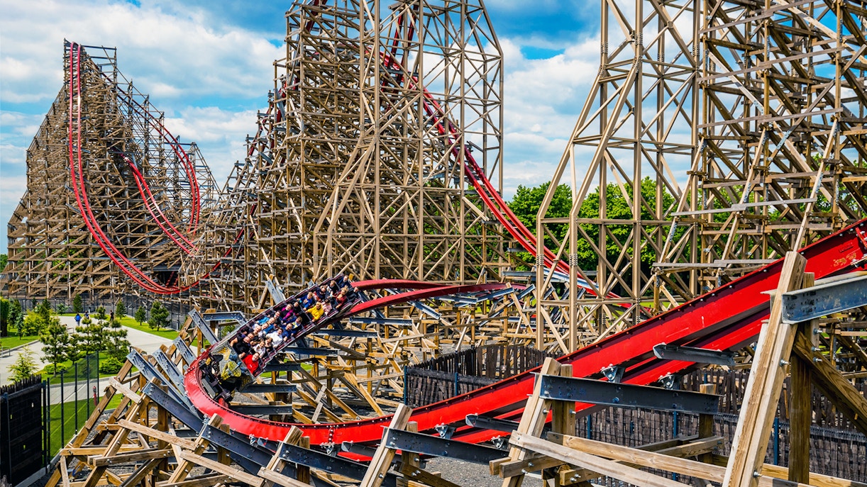 Szczęśliwa rodzina z małymi dziećmi bawi się na karuzeli w strefie Bajkolandia Energylandii